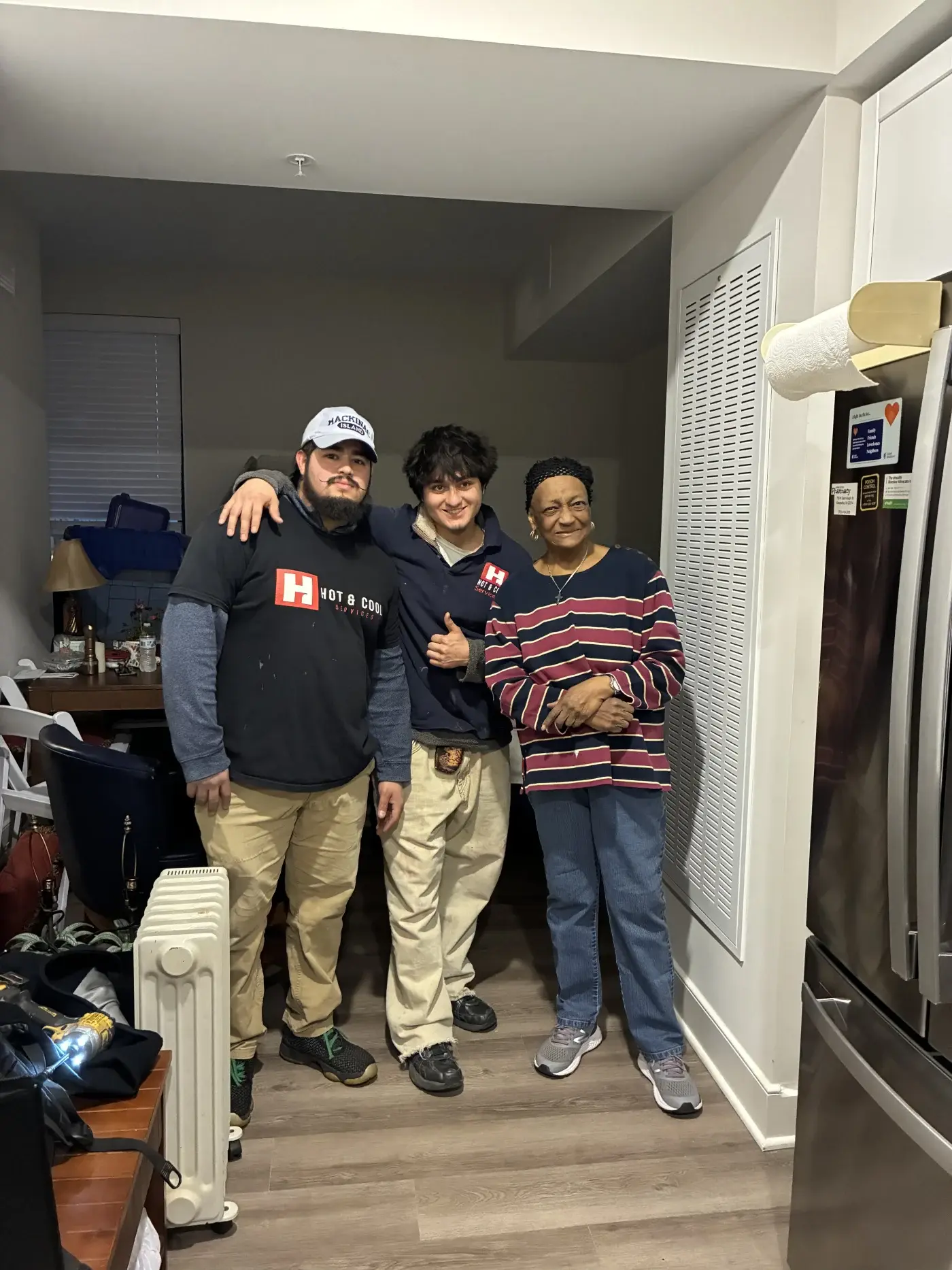 Hot & Cool Services technicians with a happy customer after HVAC service